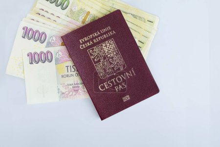Foto de República Checa pasaporte se apilan varias denominaciones CZK koruna billetes de efectivo apilados sobre fondo blanco - Imagen libre de derechos