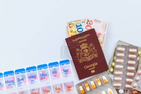 Téléchargez les photos : Passeport de Géorgie est un billet de banque appelé lari, médicaments est capsules pilules, traitement en Géorgie est de haute qualité cher - en image libre de droit
