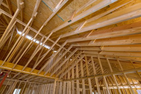 Foto de La construcción de un nuevo hogar no está terminada, incluyendo vigas, cerchas de palos, así como el encuadre de techos - Imagen libre de derechos
