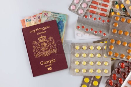 Téléchargez les photos : Traitement de haute qualité et coûteux en Géorgie est le passeport géorgien billets lari, pilules médicamenteuses capsules - en image libre de droit