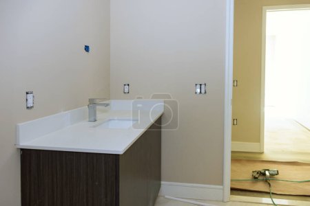 Im Badezimmer, Einbau von Waschbecken, Schrank mit Schubladen, weißes Porzellanspüle mit Edelstahlhahn