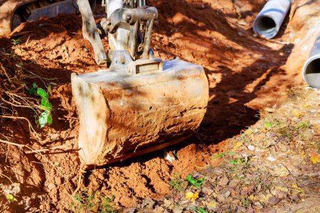 Foto de Excavadora cava trinchera a través de la cual el agua de lluvia fluirá al colector - Imagen libre de derechos