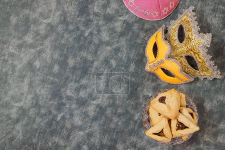 Téléchargez les photos : Juif Pourim symbole de vacances avec hamantaschen hamans oreilles cookies, masque de carnaval, bruyant - en image libre de droit
