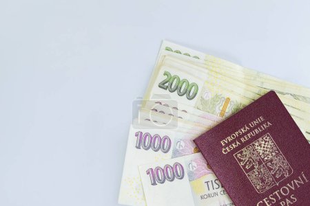 Foto de Varias denominaciones de billetes de coronas checas se apilan sobre fondo blanco en el pasaporte de la República Checa - Imagen libre de derechos