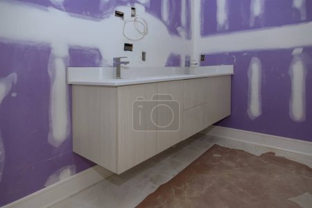 Installation of cabinet with drawers for wash basins, stainless steel faucet for sink at toilet, white porcelain sink