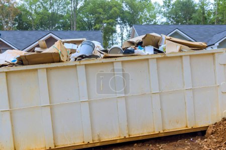 Metal container dumpster is available at construction site for disposal of repair junk waste