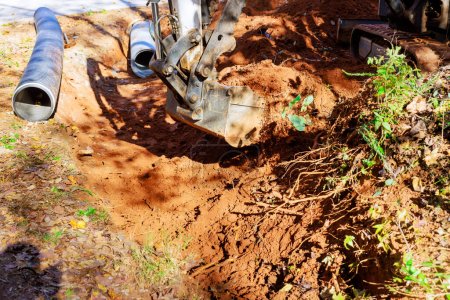 Foto de Excavadoras cavan trincheras para la colocación de tuberías a través de las cuales se recogerá el agua de lluvia - Imagen libre de derechos