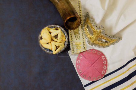 Téléchargez les photos : Il existe un lien entre les hochets Pourim juifs de vacances, masques de carnaval, biscuits hamantaschen qui symbolisent sa célébration. - en image libre de droit