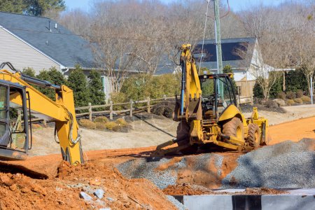 During earthmoving operations to prepare an infrastructure area, an excavator digs trenches