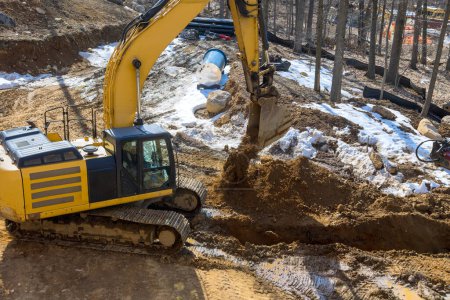 Excavators dig trenches on construction site during earthmoving works preparing infrastructure