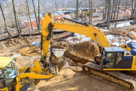 Large excavator is digging on an industrial site for development of infrastructure