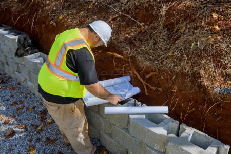 When mounting retaining walls with cement blocks, construction workers typically use blueprints