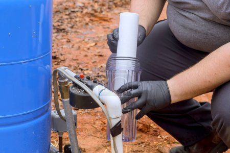 Installation of new water purification filter cartridge by maintenance serviceman