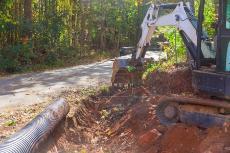 Excavadora excavación trincheras para la colocación de tuberías que llevará el agua de lluvia al sistema de recolección