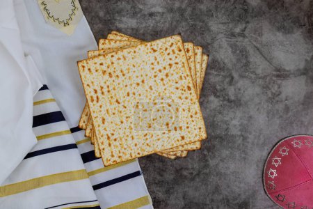 Tradition of Jewish people with Matzah, Passover unleavened bread, kippah, tallit are symbols of Pesach celebration.