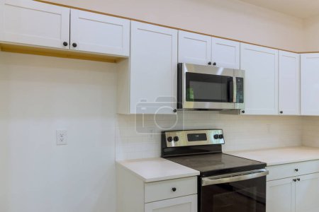 Wooden white kitchen cabinets are being installed in new house newly constructed