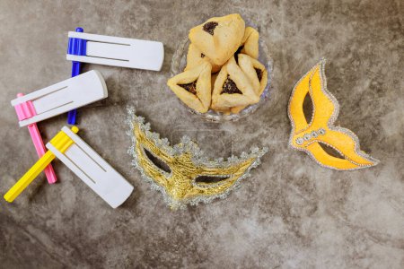 Téléchargez les photos : En tant que symboles de célébration, Pourim fête juive est associée à hochets, masques de carnaval, biscuits hamantaschen - en image libre de droit
