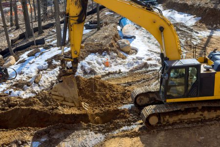 Large excavator is digging earthwork on an industrial site under construction