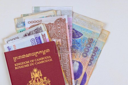 Kingdom of Cambodia Passports over Cambodian national currency banknotes of different nominal values