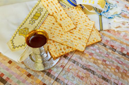 Matzah unleavened bread, wine cup adorned with Passover holidays symbols