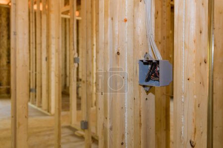 Photo for An electrical switch box plastic mounted wires on wooden frame beams on wall - Royalty Free Image