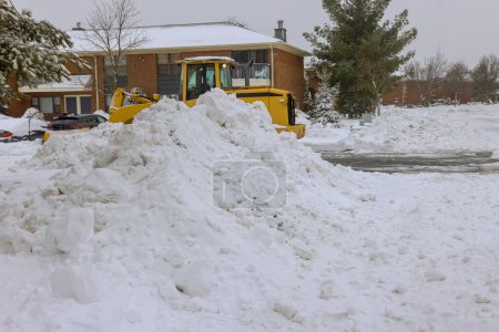 After heavy snowfalls, snowplow truck removes snow from parking lot