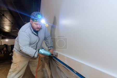 Entrepreneur clous moulures en bois garniture lors de l'installation à la nouvelle maison en utilisant pistolet à air