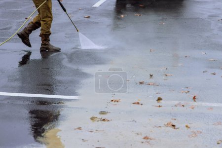 Street is sprayed clean with pressurized water during wet washing process