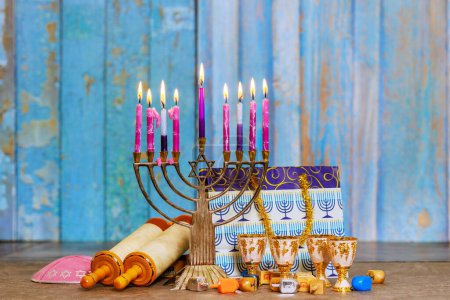 Hanukkiah Menorah with candles burning is traditional symbol of Jewish faith during holiday Hanukkah