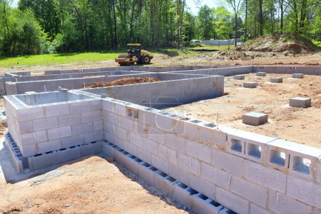 On construction site, cement blocks have been installed as foundation for walls of house