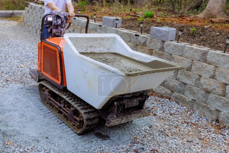 Téléchargez les photos : Utilisation d'une voie en caoutchouc auto-vidange camion en béton pour transporter le béton sur le chantier de construction - en image libre de droit