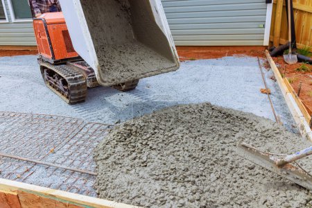 Téléchargez les photos : Camion buggy béton est utilisé pour verser du ciment humide dans le cadre pendant la construction de la fondation - en image libre de droit