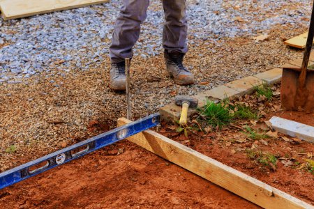 El encofrado para verter hormigón sobre cimientos es producido por trabajadores que utilizan plantillas de madera extraíbles