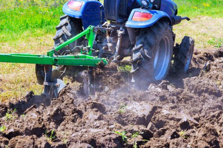 Traktorpflüge bereiten Feld vor, kultivieren Boden für die Aussaat von Getreide im Frühjahr