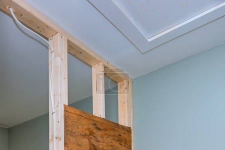 Photo for Drywall screwing plasterboard mounting to wooden beams at wall - Royalty Free Image