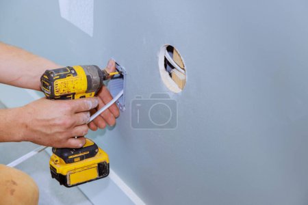 Photo for Professional electrician installing an electric socket in wall of renovation room electrical system - Royalty Free Image