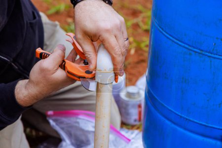 Klempner schneiden PVC-Rohre bei Reparaturarbeiten mit spezieller Schere