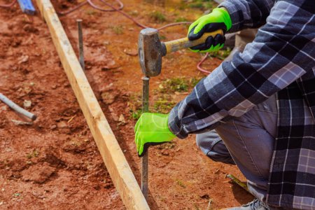 Plantillas de producción de trabajadores con encofrado de madera extraíble para verter cemento sobre cimientos