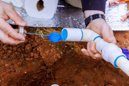 Bevor PVC-Kunststoffrohr verklebt wird, versiegelt Klempner es mit Kleber