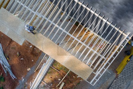 Tischler hämmert bei Bauarbeiten Nagel in OSB-Sperrholzplatte auf Dach
