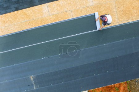 Photo for Installing new asphalt bitumen shingles on home roof - Royalty Free Image