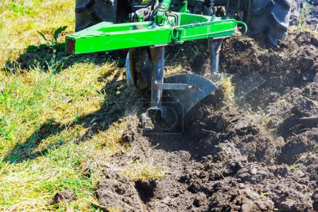Campo de arados tractor cultiva el suelo para la siembra de primavera de grano
