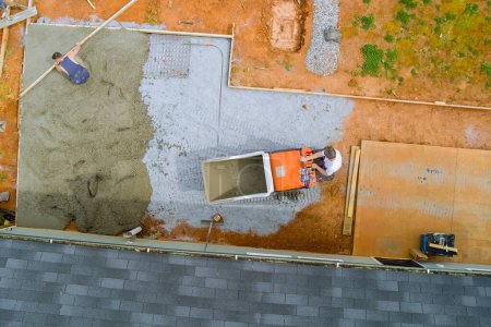 Téléchargez les photos : Auto dumping voie buggy béton est utilisé pour verser du ciment humide dans le cadre pendant la construction de la fondation - en image libre de droit