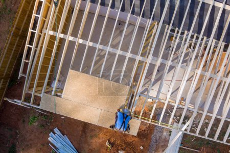 Bauarbeiter hämmert Nägel in OSB-Sperrholzplatte auf Dach