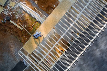 Schreiner schlägt bei Bauarbeiten Nagel in OSB-Sperrholzplatte auf Dach