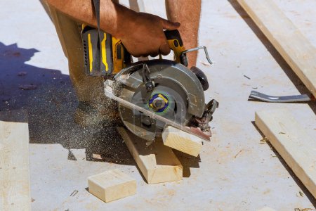 Photo for Woodworking carpenter cutting wooden beams with handsaw - Royalty Free Image