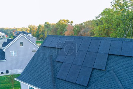 On roof of house are solar photovoltaic panels which generate green power, renewable energy source