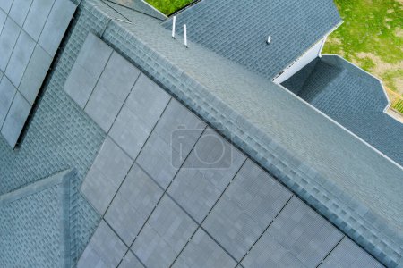 Photo for Roof of house is covered with solar photovoltaic panels powered by green power, renewable energy source - Royalty Free Image