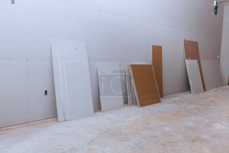 Newly constructed house walls are plasterboard drywall that are getting ready to be plastered