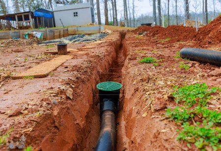 Installation de drains pluviaux dans les drains de tranchées afin de drainer l'eau de pluie